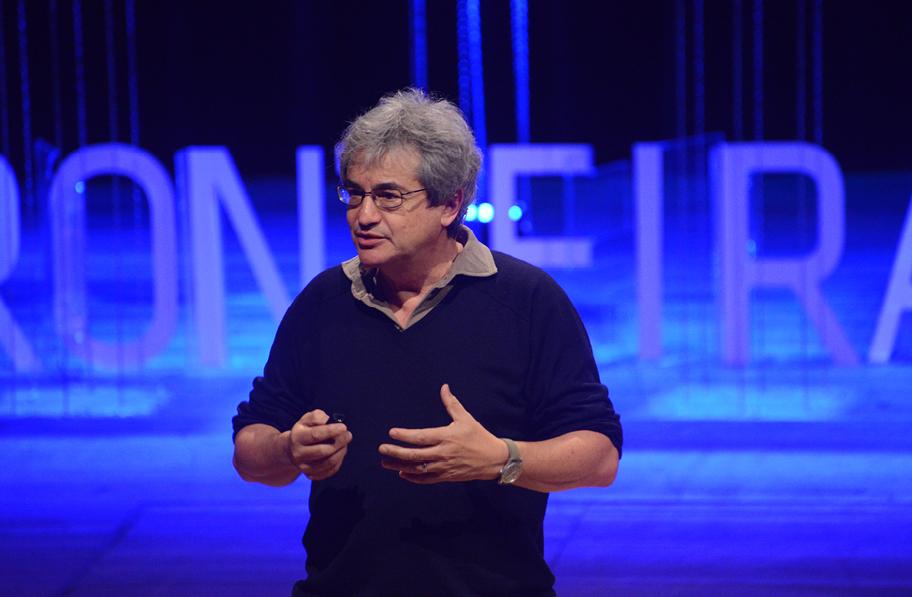 Carlo Rovelli luennoi sinisen taustan edessä.